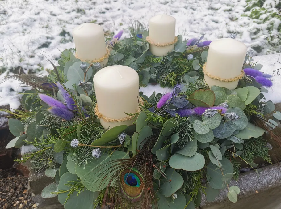 Four candles on a decorative outdoor wreath.