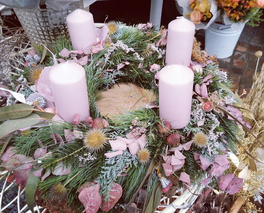 Advent wreath with four pink candles and greenery.