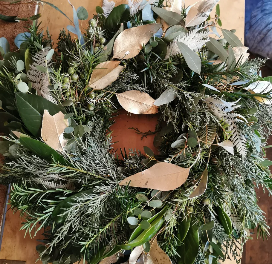 Decorative wreath with green and gold leaves.