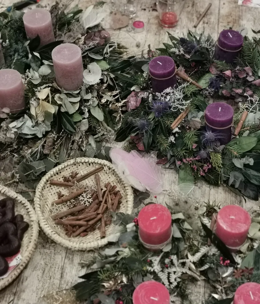 Kerzen auf dekorativen Kränzen auf einem Tisch.