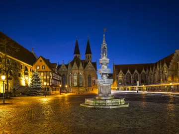 Fountain in the middle, surrounded by historic buildings.