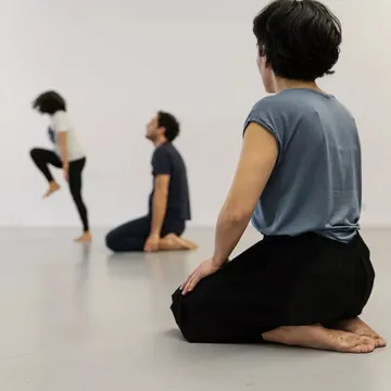 Menschen meditieren in einem Studio.