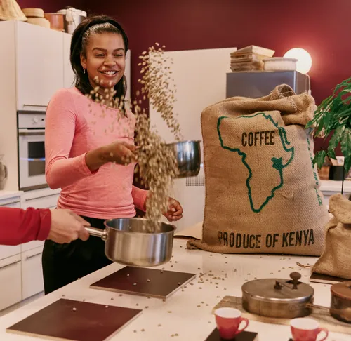 Woman pouring coffee beans in kitchen.