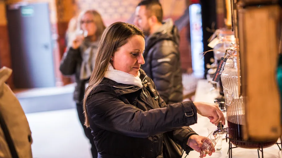 Woman pouring cider in tasting room.