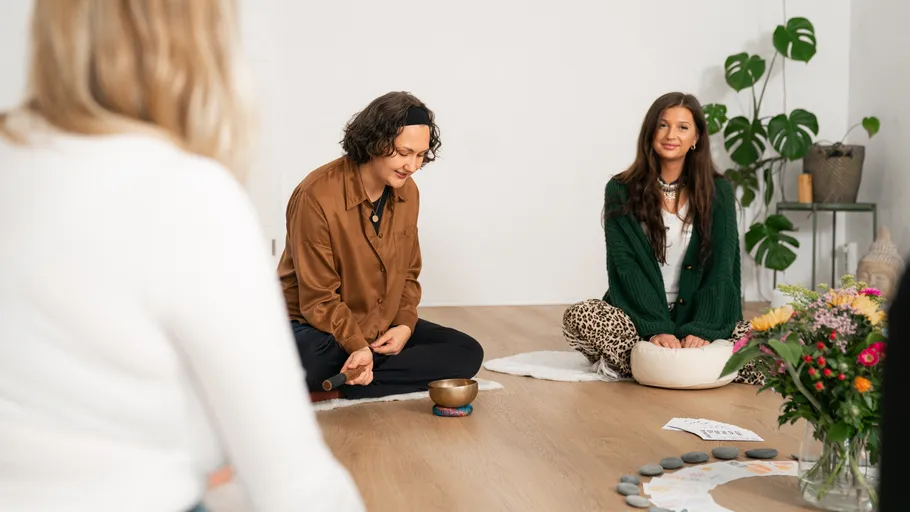 People meditating in a peaceful room setting.