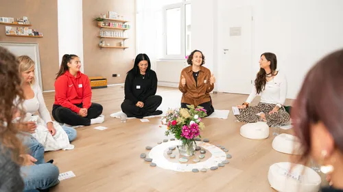 People sitting in circle, participating in group activity.