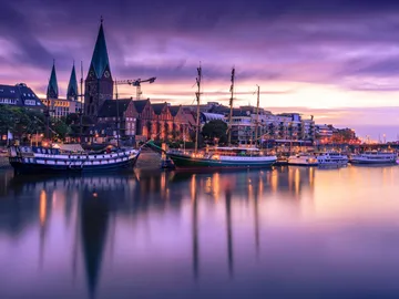 Ships lie quietly at the harbor under cloudy skies.
