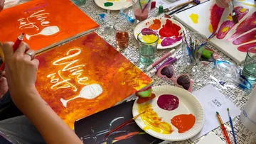 Personen malen Leinwände im Kunstkurs.
