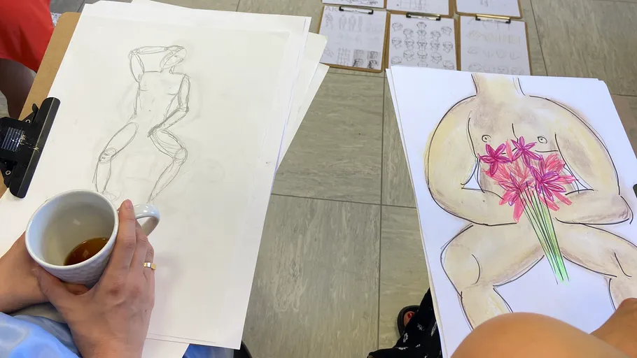 Person zeichnet menschliche Figuren im Kunstkurs.