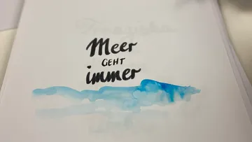Watercolor text art with blue paint.