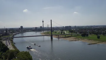 Bridge spanning river in city landscape.