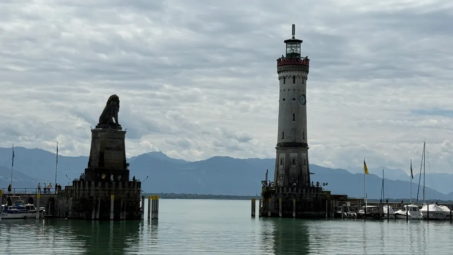 Lion statue and lighthouse at harbor entrance.