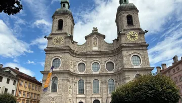 Stone cathedral with twin towers, blue sky.