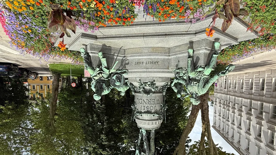Statue surrounded by flowers in urban park.