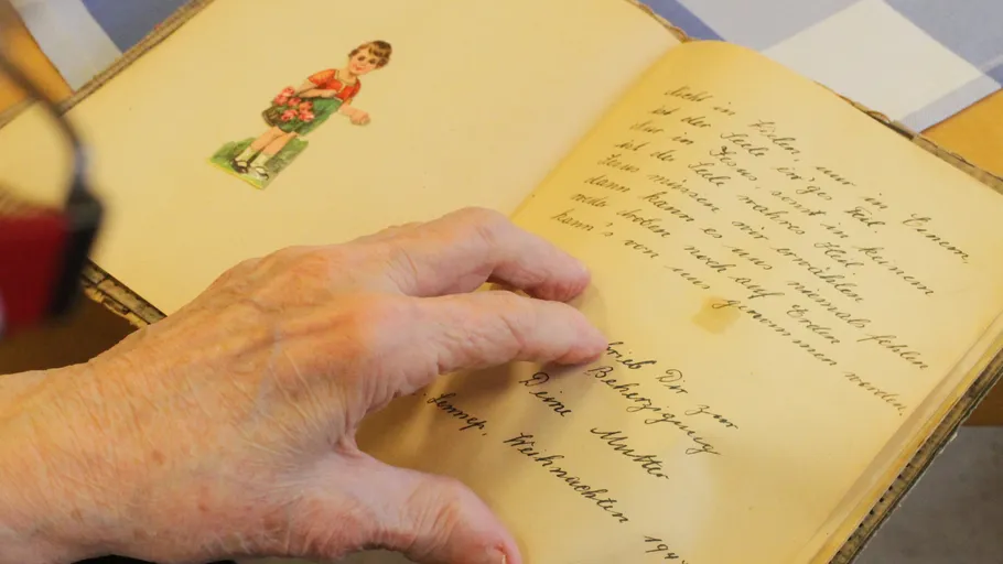 Hand blättert in einem alten Buch.