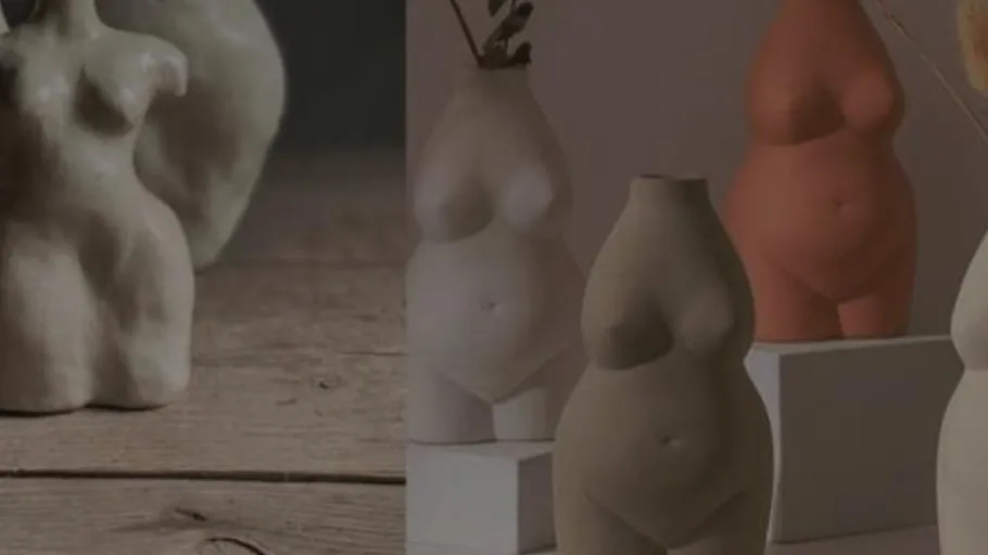 Ceramic vases shaped like human torsos on display.