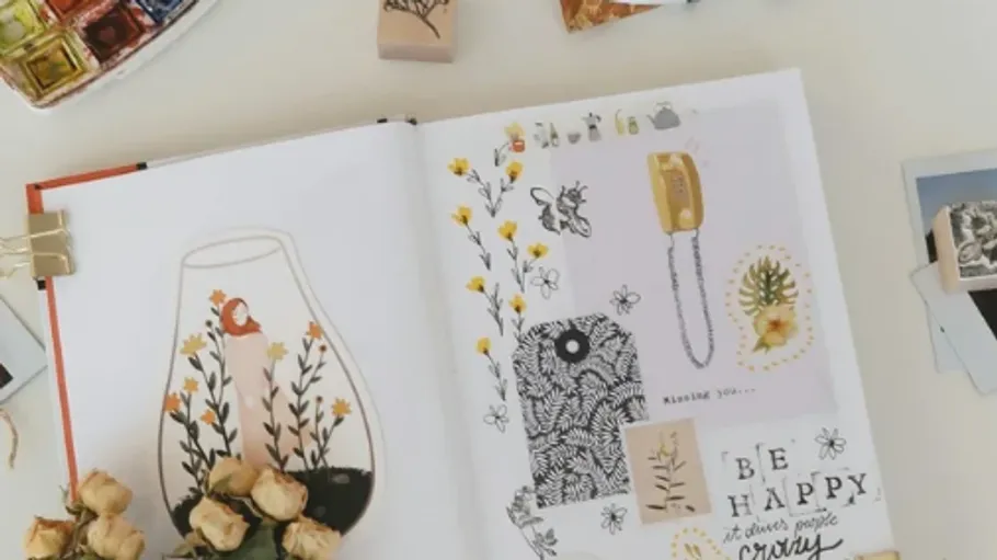 Offenes Scrapbook mit Blumendekorationen, Stempeln und Text.