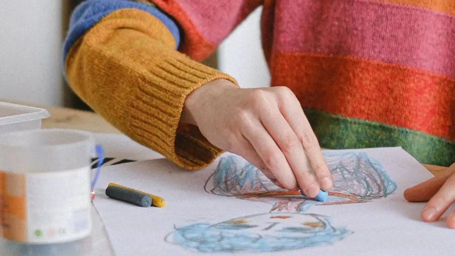 Person drawing colorful portrait with pastels.