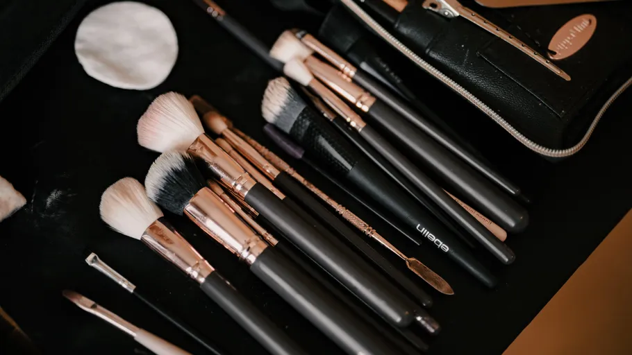 Makeup brushes neatly arranged on black surface.