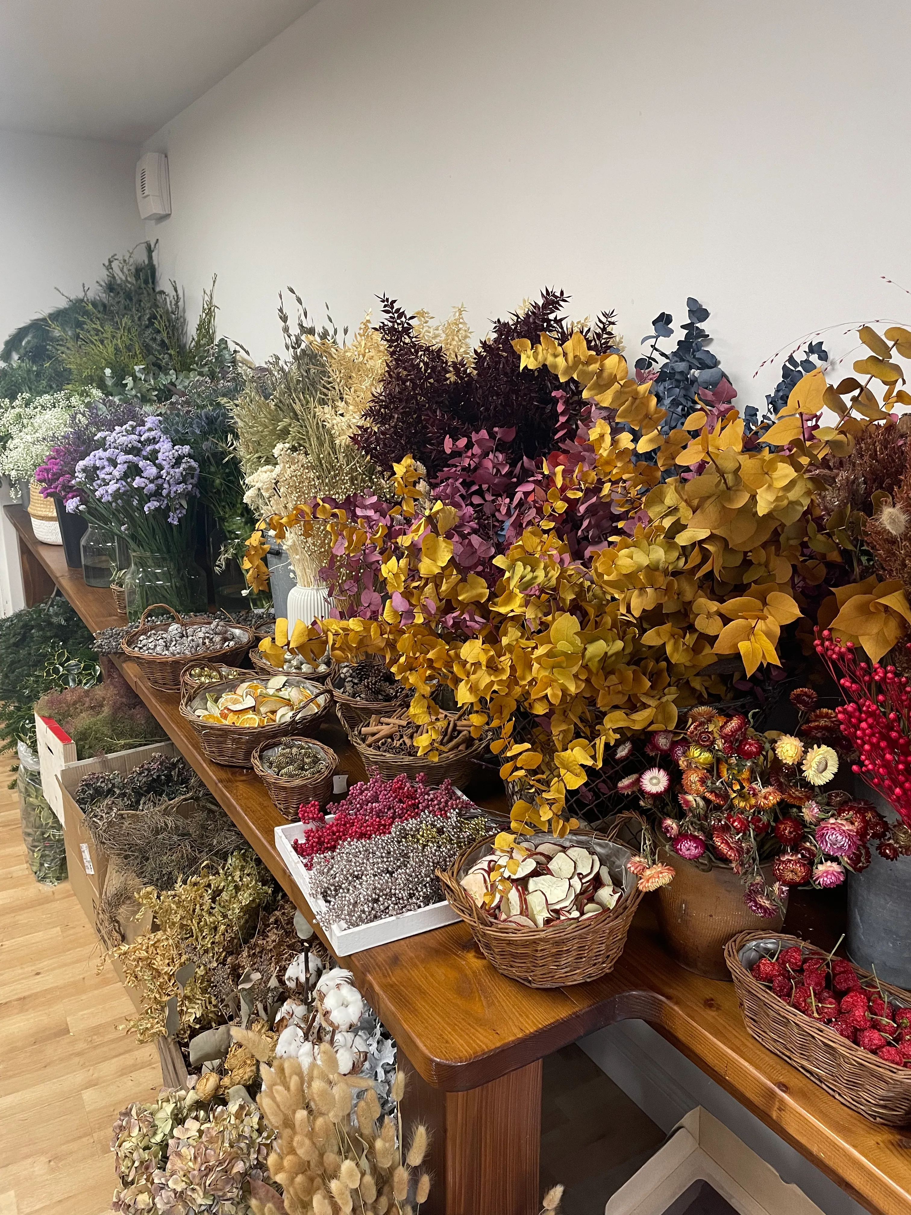 Dried flowers and plants on wooden table.