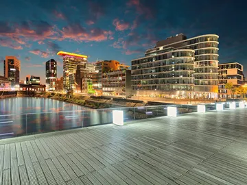 Städtische Gebäude reflektieren das Licht am Wasser bei Dämmerung.