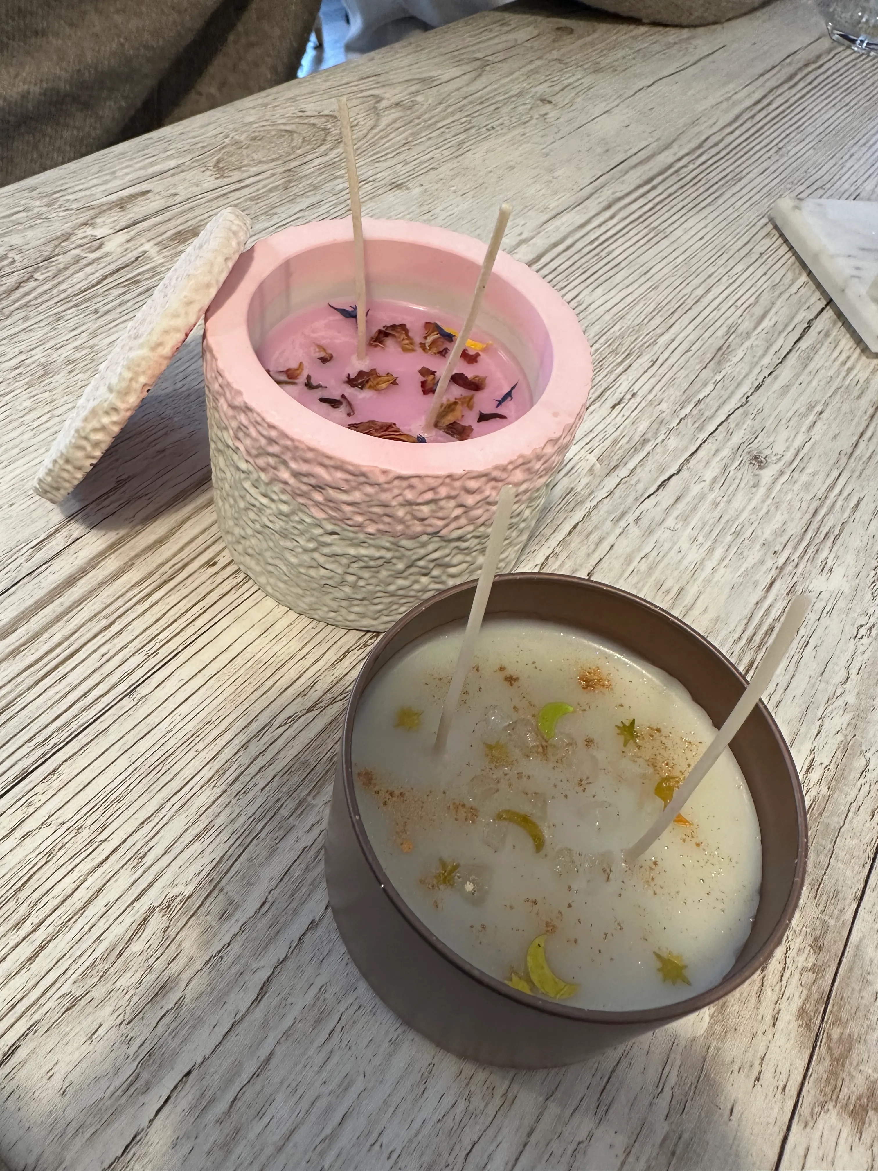 Zwei verzierte Kerzen auf Holztisch.