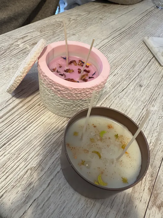 Two decorated candles on wooden table.