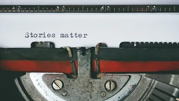 Schreibmaschine tippt 'Stories matter' auf Papier.