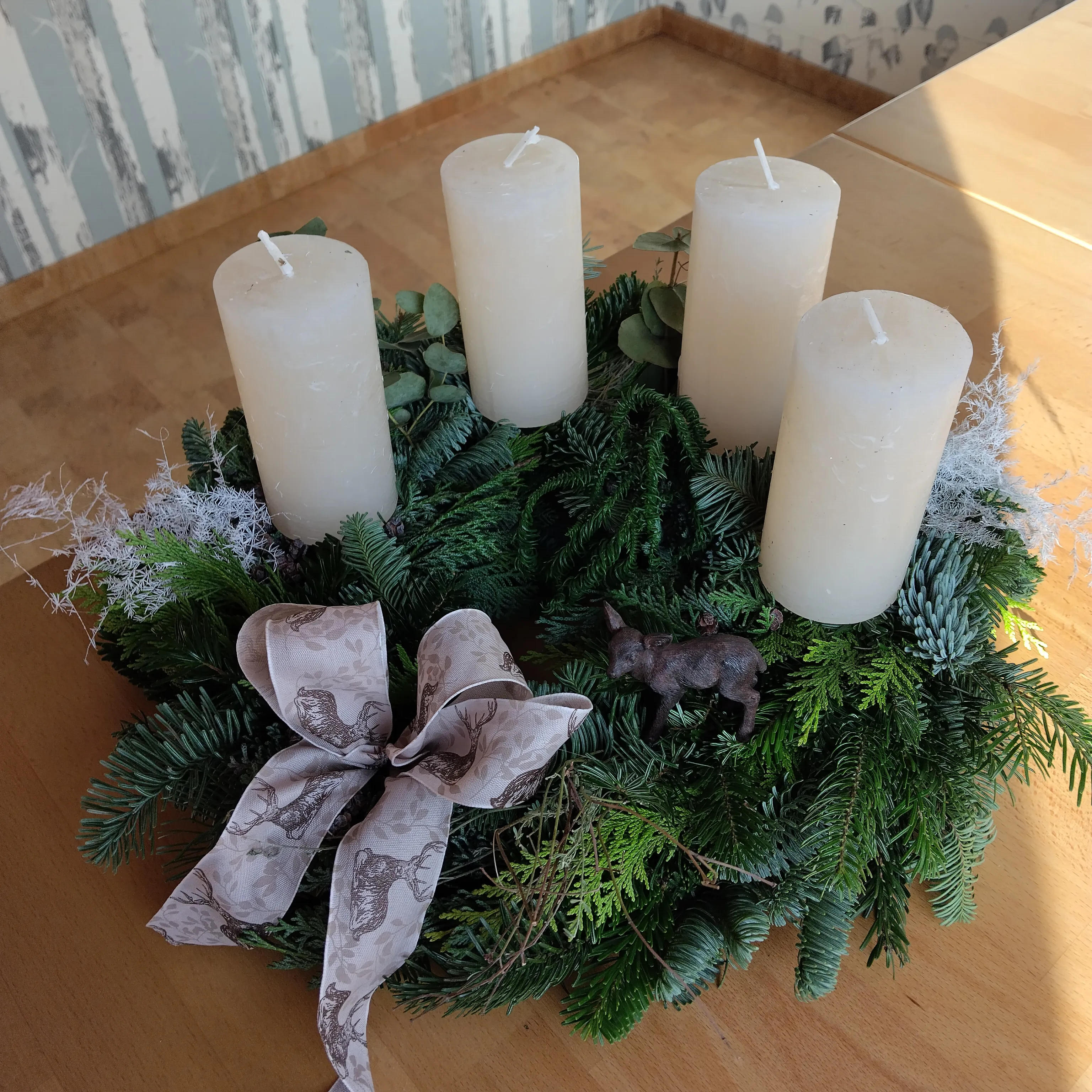 Vier Kerzen auf einem festlichen Kranz Tisch.