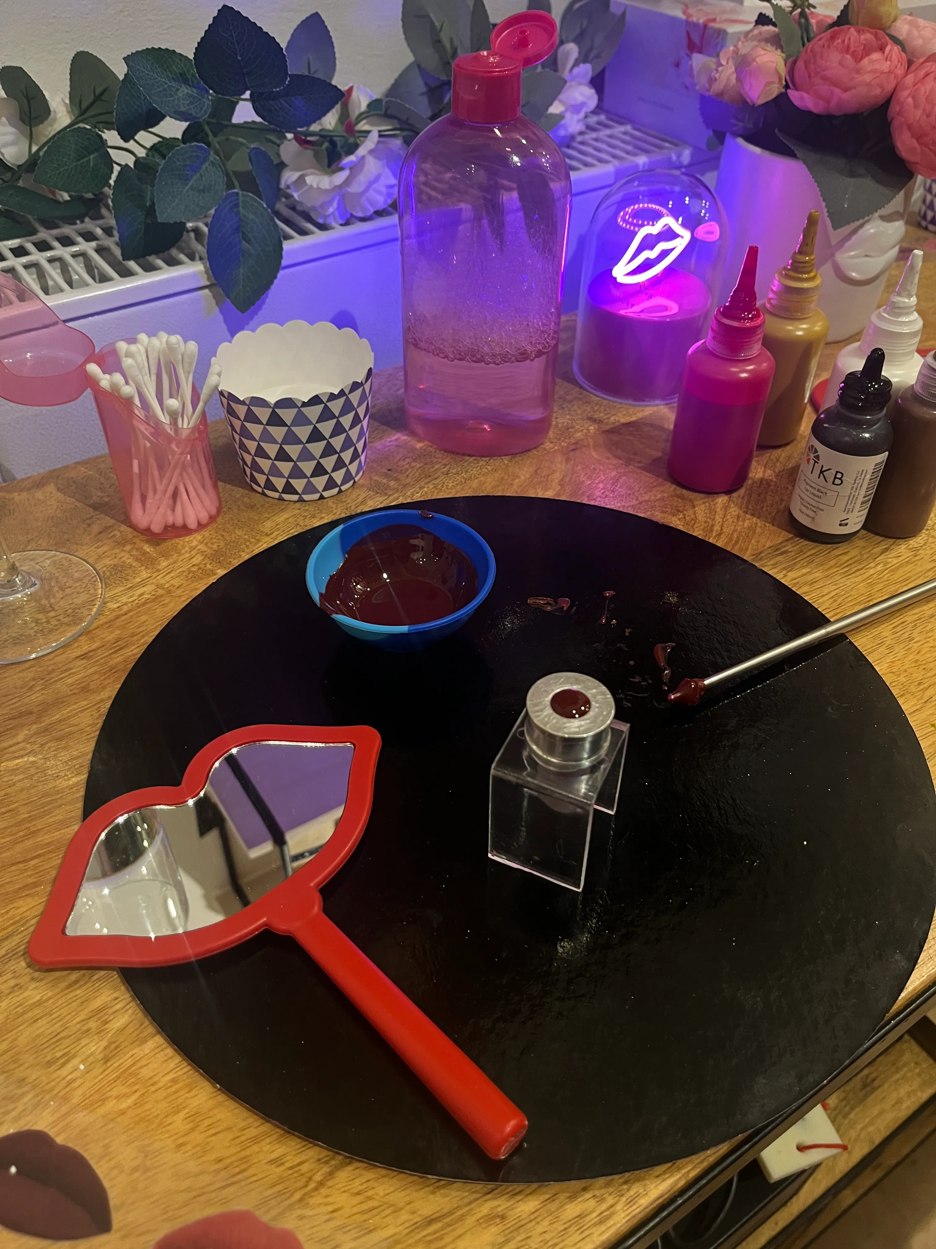 Lip-shaped mirror on a table with cosmetics.