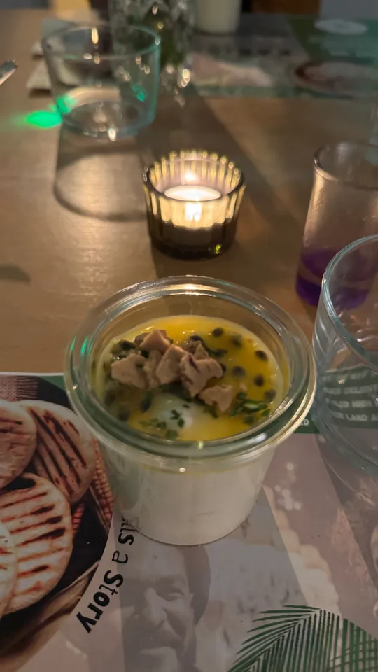 Dessertglas mit Kerzenlicht auf Tisch.