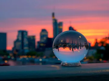 Glaskugel reflektiert Skyline bei Sonnenuntergang in Frankfurt.