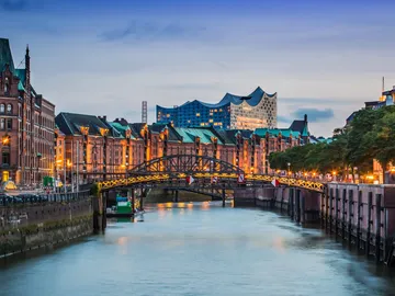 Brücke über ruhigen Kanal, historische Gebäude im Hintergrund.