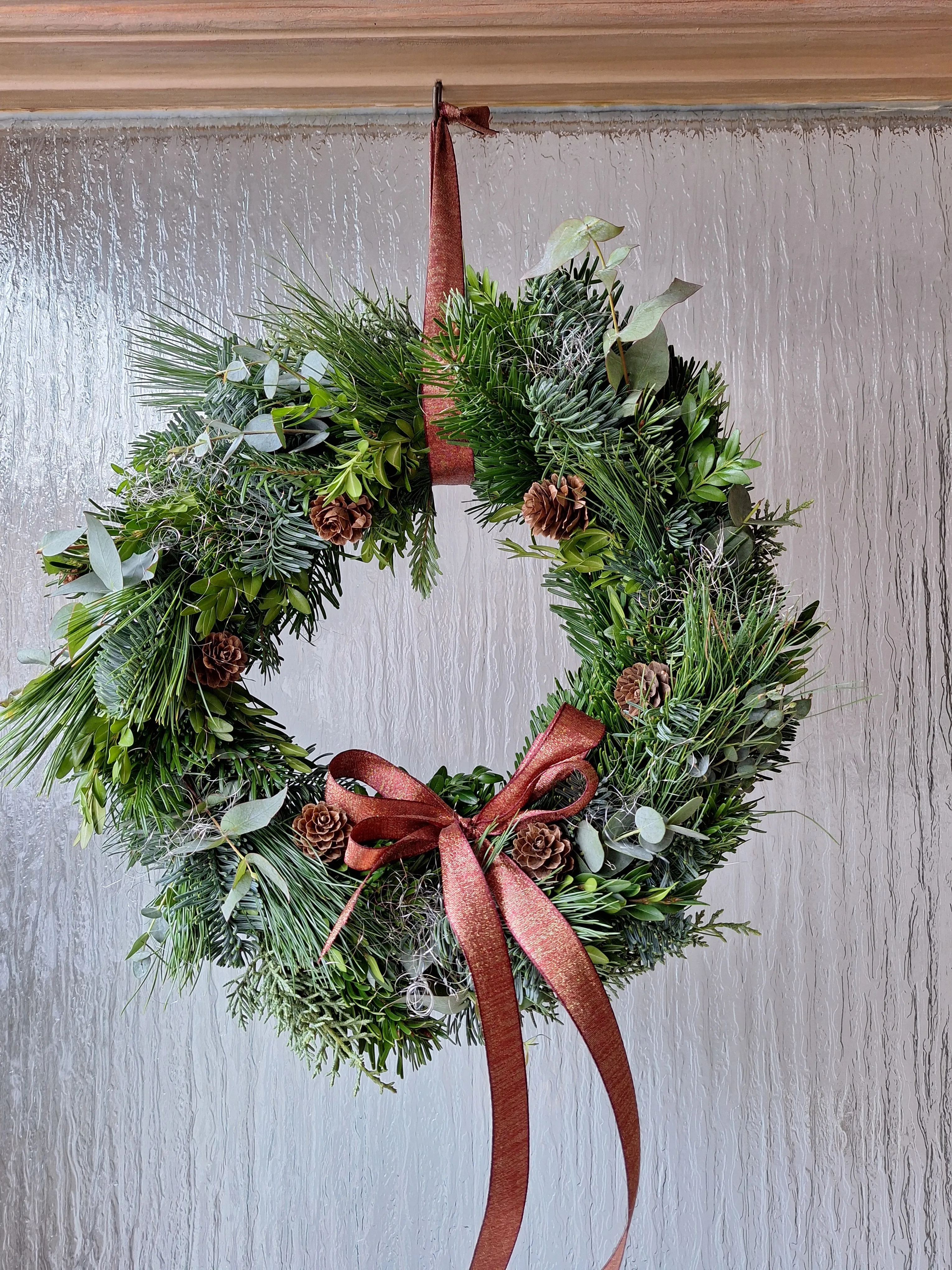 Holiday wreath with red ribbon on door.