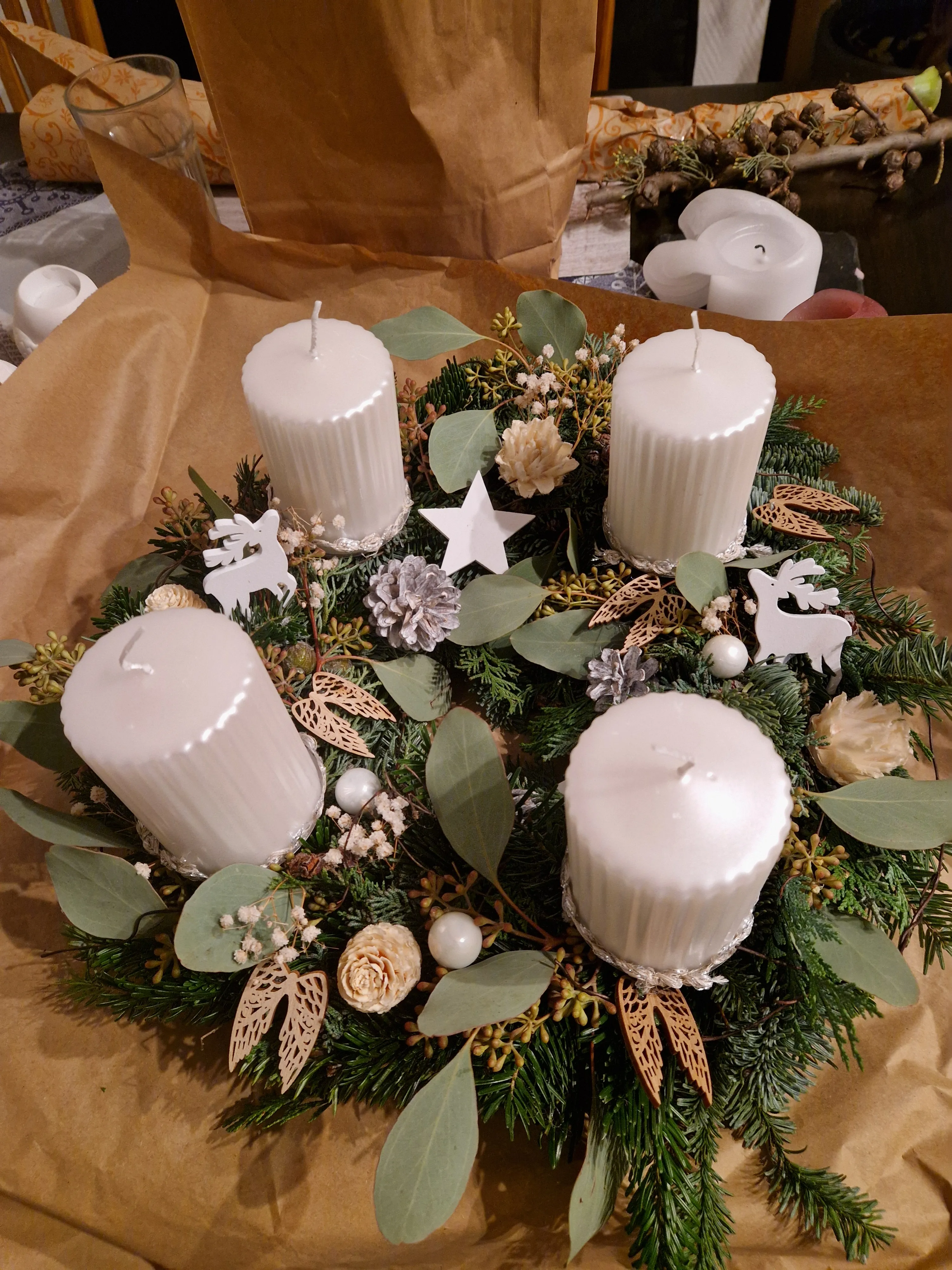 Adventskranz mit weißen Kerzen und Grün.