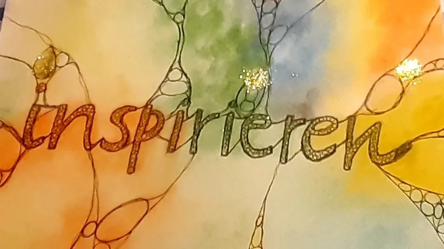 Text "inspirieren" auf buntem abstrakten Hintergrund.