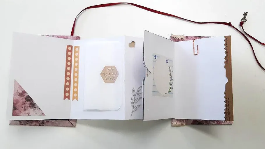Open scrapbook with papers and ribbon.