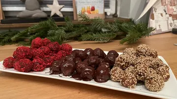 Assorted chocolate truffles on a rectangular plate.