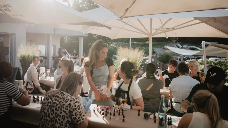 People painting under outdoor umbrellas.