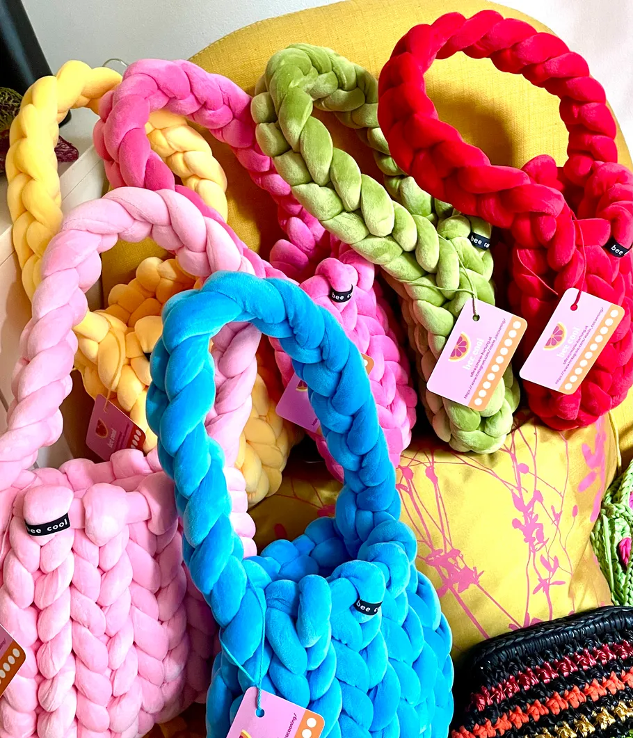 Colorful braided bags on a yellow chair.