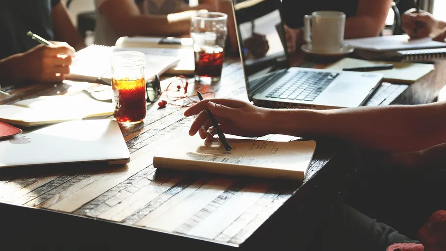 People collaborating at a wooden table.