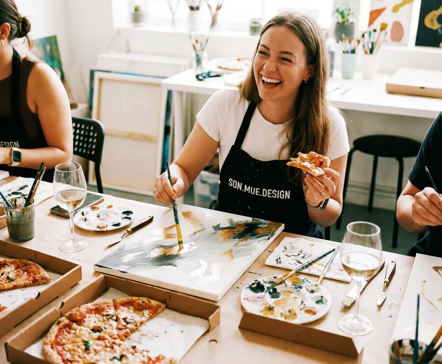 Woman painting and eating pizza in studio.