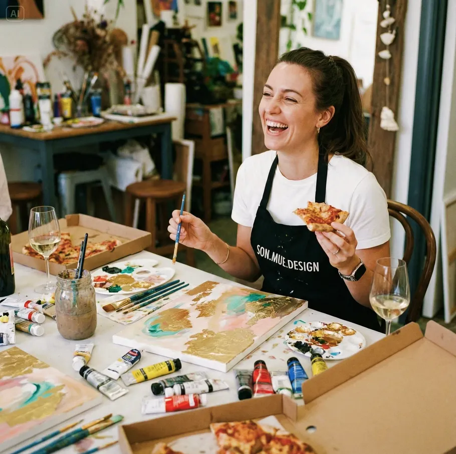 Woman painting and eating pizza, art studio.