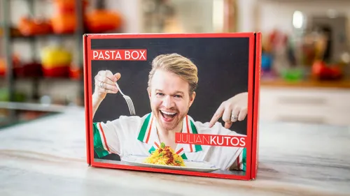 Pasta box featuring smiling person in kitchen.