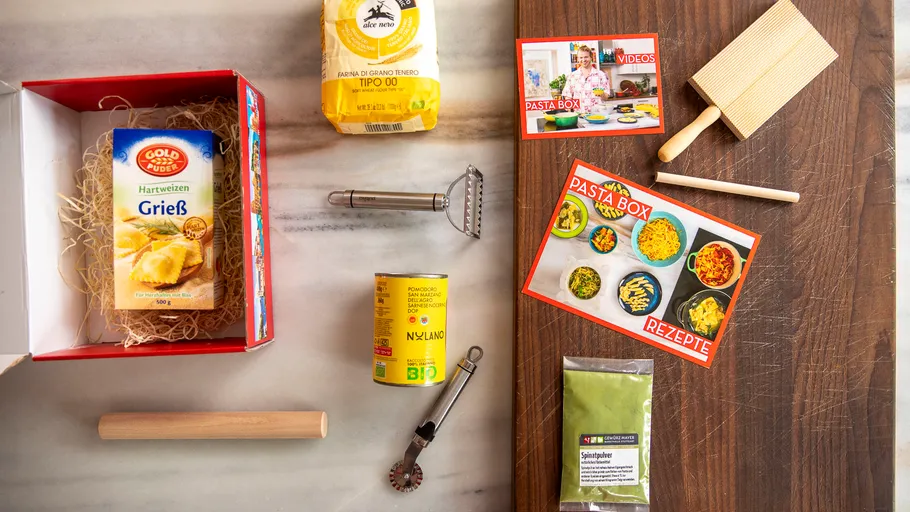 Pasta kit contents arranged on marble and wood.