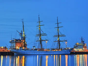 A ship is quietly moored in port at night.