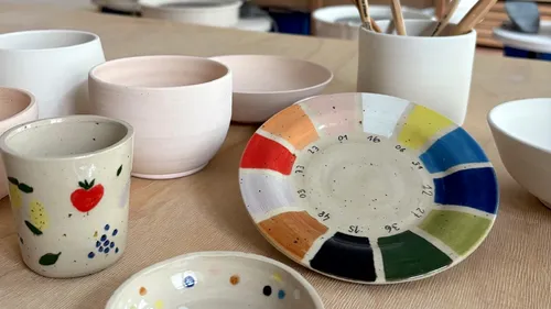 Colorful ceramic dishes displayed on wooden table.