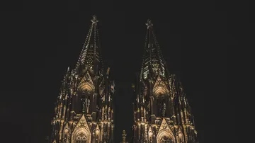 Beleuchtete Kathedralen Türme vor Nachthimmel.