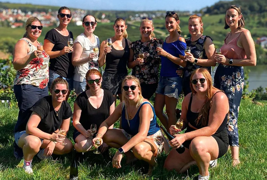 Group of women holding wine glasses outdoors.