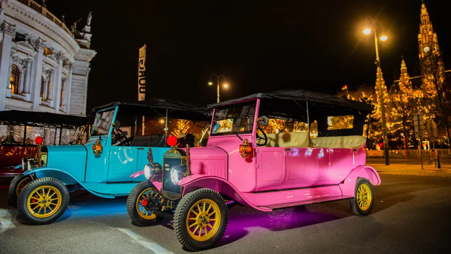 Oldtimer parken nahe beleuchteten Gebäuden.